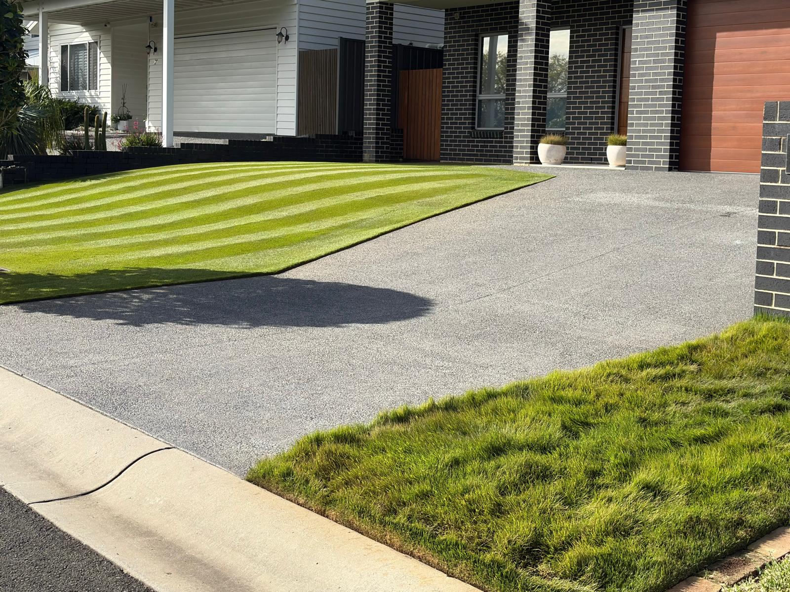 Precisely striped front lawn framed by a modern home